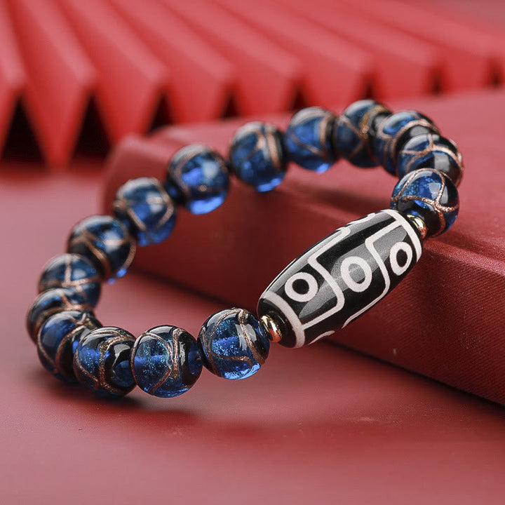 Armband – Wohlstand Balance mit blauen Perlen und silbernem Dzi-Amulett elegant.