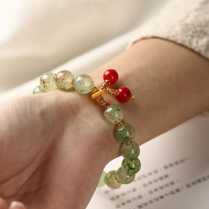 Armband – Harmonie & Segen mit grünen Kristallperlen und roten Akzenten