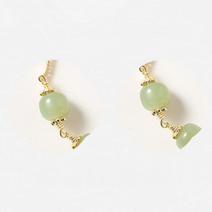 Jade Ohrringe mit grünen Steinen und goldfarbenen Metallbeschlägen elegant.