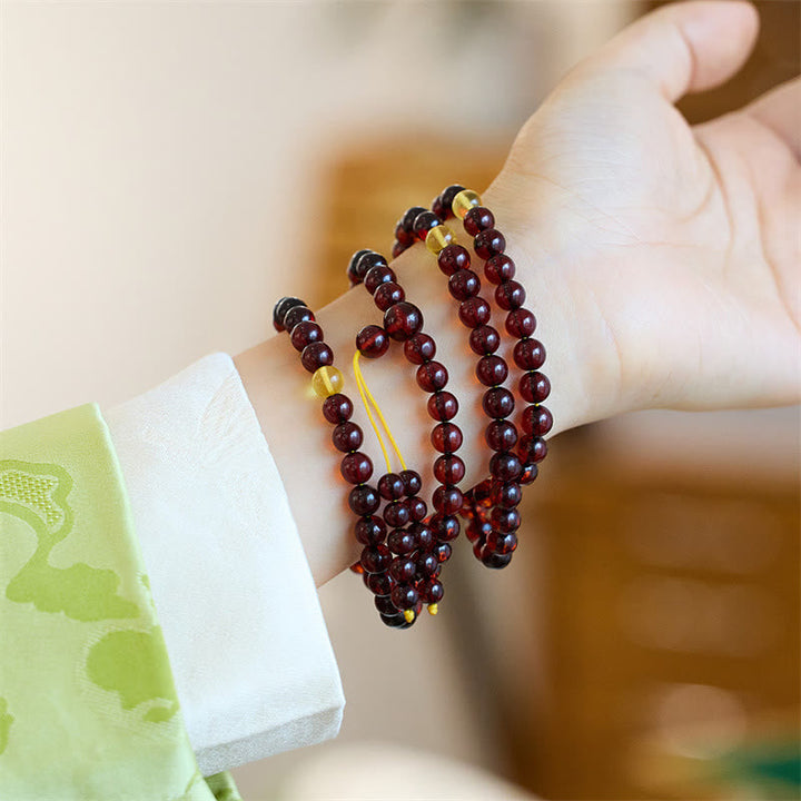 Mala 108 Perlen Amber – Energie Armband am Handgelenk getragen braun glänzend