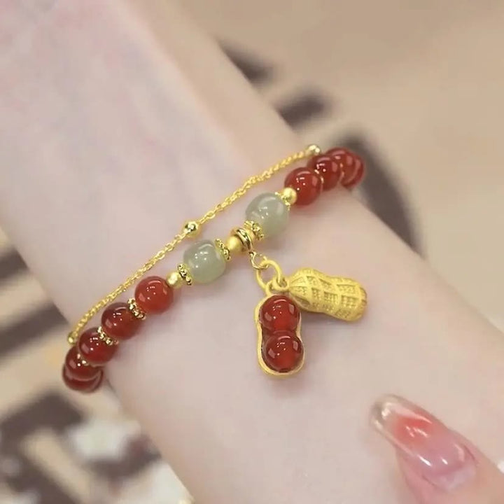 Jade Armband mit roten Perlen und goldenen Fu-Zeichen Anhängern elegant.
