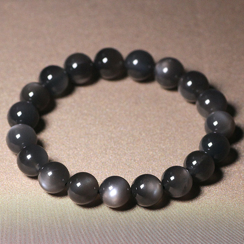 Mondstein Armband mit glänzenden schwarzen Perlen elastisch getragen