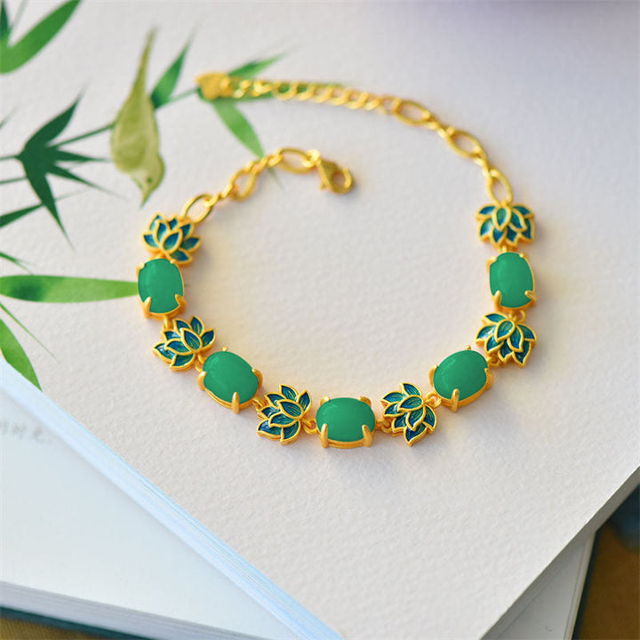 Grünes Jade Armband mit goldfarbenen Lotus-Perlen auf weißem Hintergrund.