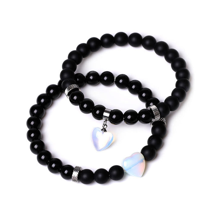Armband Schwarzer Onyx Kristall Paar mit opaleszierenden Herzanhängern elegant.