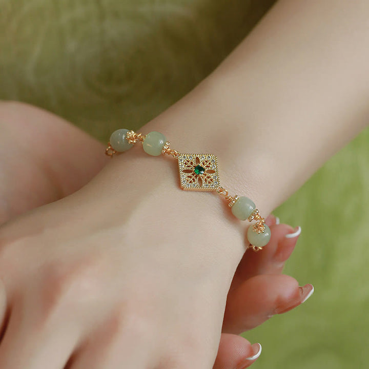 Jade Hetian Armband mit goldenem Charm am Handgelenk elegante Natursteine