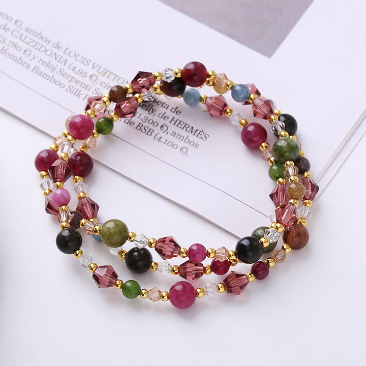 Mehrsträngiges Armband mit Rosenquarz, Amethyst und Natursteinen auf Papier.