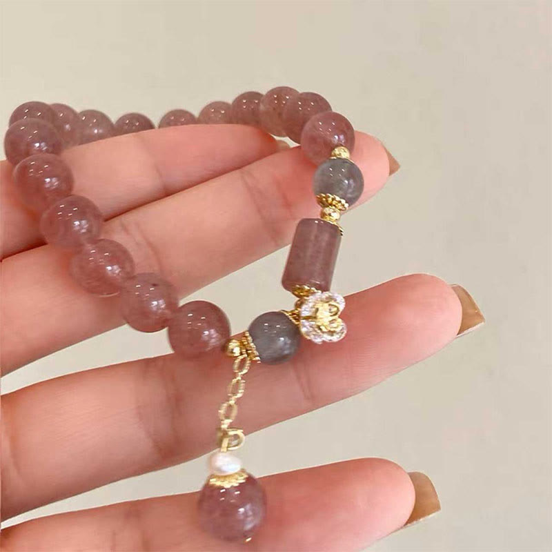 Armband Erdbeerquarz – Segen am Handgelenk mit goldenen Elementen getragen