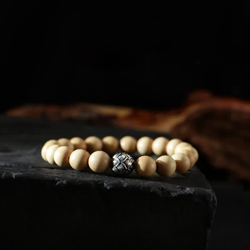 Holzperlen-Armband mit silbernem Mittelstück auf schwarzem Stein Nahaufnahme
