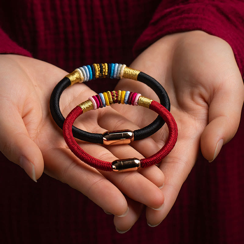 Magnetische Armbänder mit farbigen Perlen in Händen gehalten.