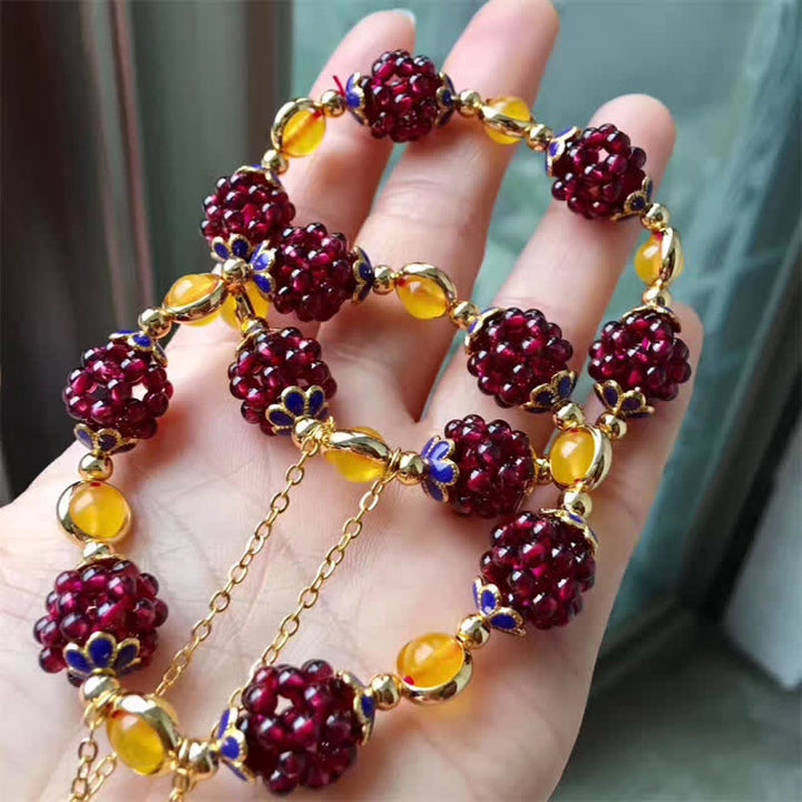Armband Granat am Handgelenk mit roten Steinen und goldenen Perlen