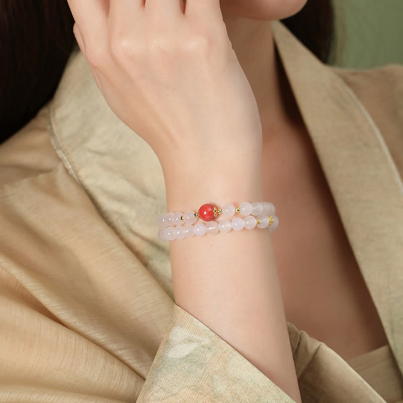 Rosenquarz Armband mit rotem Zinnober Perle elegant getragen