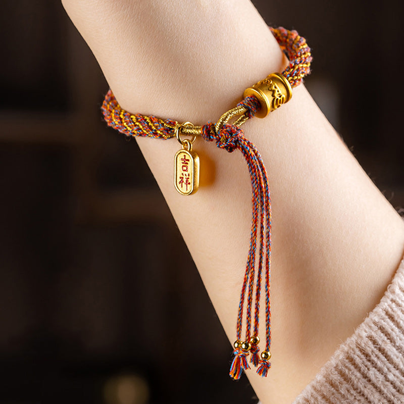 Armband Om Mani Padme Hum Multicolored mit Goldelementen am Handgelenk getragen.