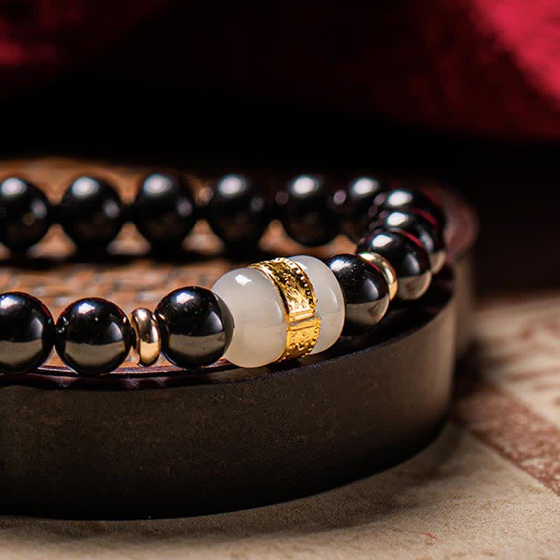 Schwarzer Obsidian Armband mit weißem Jade Stein und goldenem Akzent elegant.