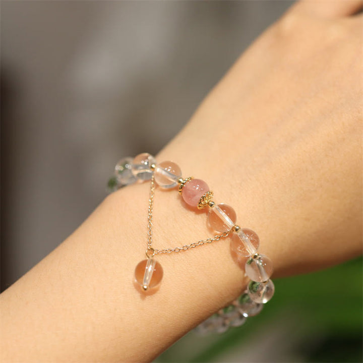 Zartes Silberarmband mit Rosenquarz und Kristallperlen am Handgelenk.