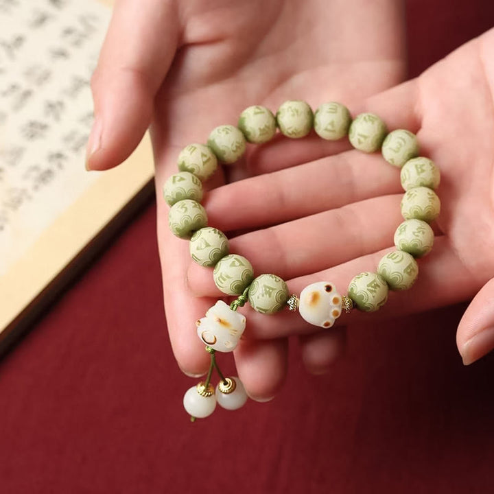 Grünes Bodhi-Armband mit Om-Perlen elegant am Handgelenk getragen.