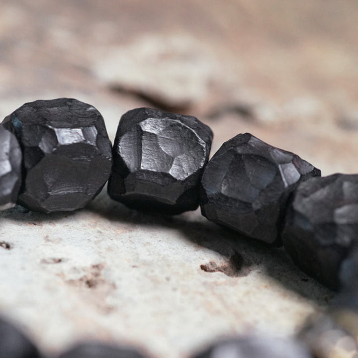 Schwarze facettierte Ebenhölzer Mala Kupfer Ebenholz Frieden Naturstein