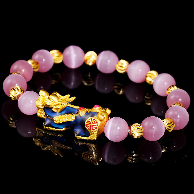 Armband Pixiu – Glück rosafarbene Perlen goldene Pixiu-Figur schwarzer Hintergrund