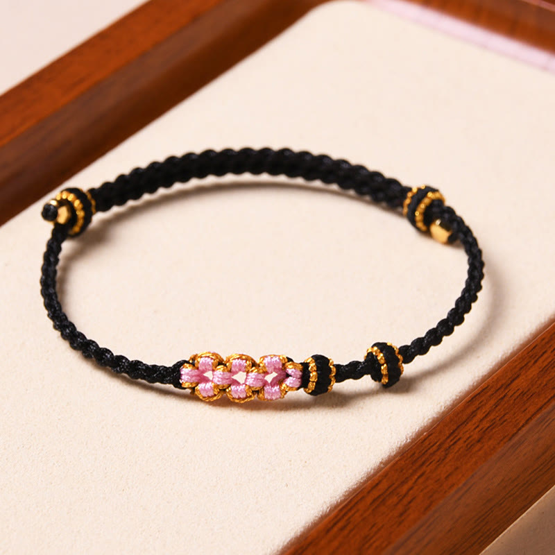 Armband Pfirsichblüte – Schutz schwarzes Seil rosa Blüten goldene Perlen
