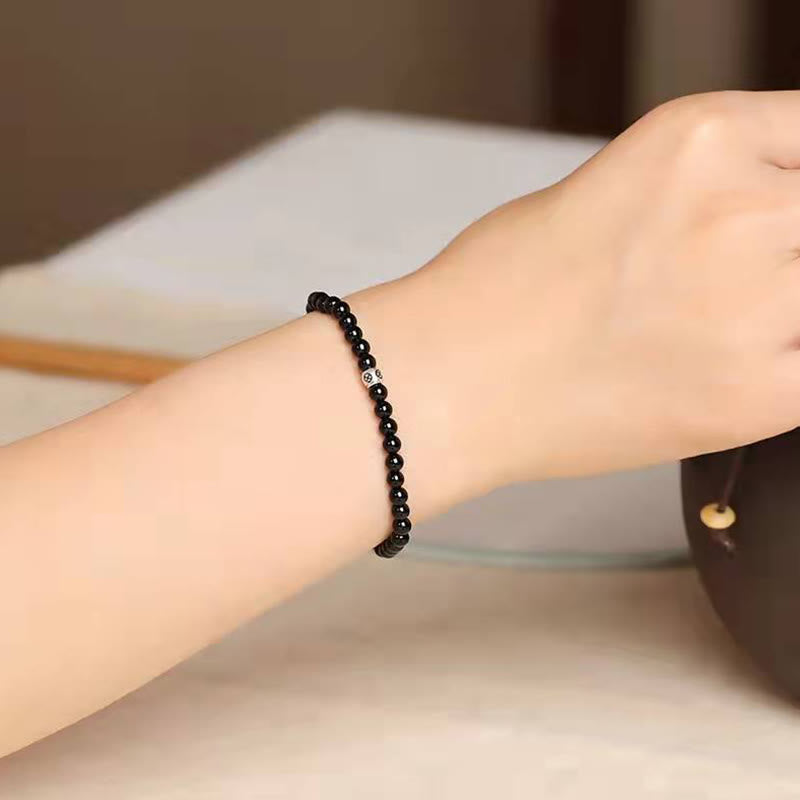 Schwarzer Obsidian Armband mit Katze Symbol am Handgelenk getragen elegant