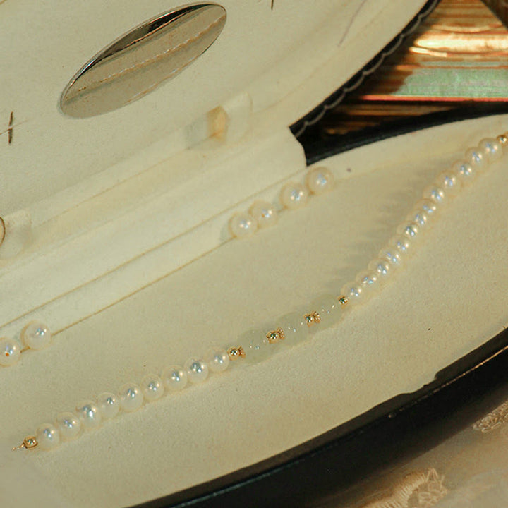 Armband Weiße Jade mit Perlen und Goldakzenten elegant präsentiert