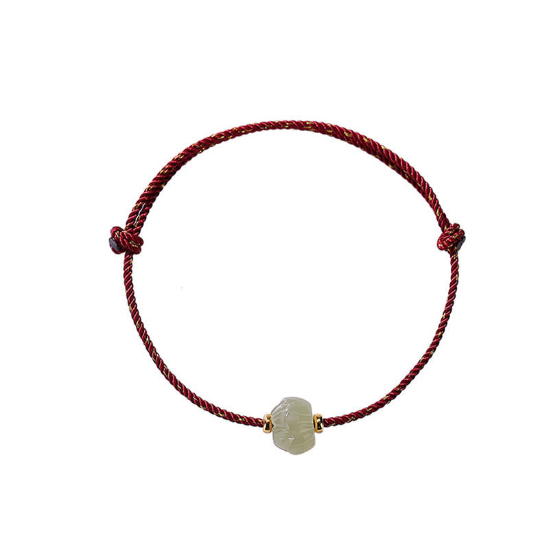 Jadegrünes Lotus-Armband mit roter Kordel, elegantes Designstück.