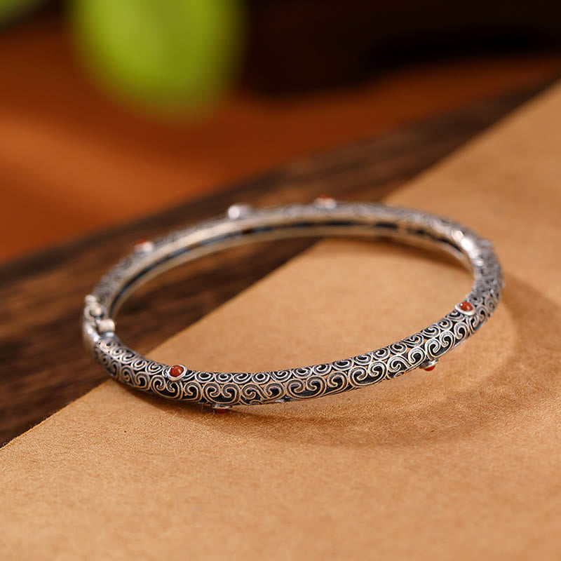 Silbernes Armband mit Muster auf braunem Leder, elegantes Design.