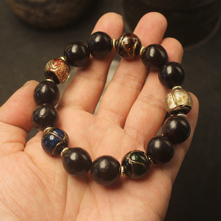 Armband – Wohlstand Harmonie schwarze Perlen mit goldenen Perlenkappe Handgelenk