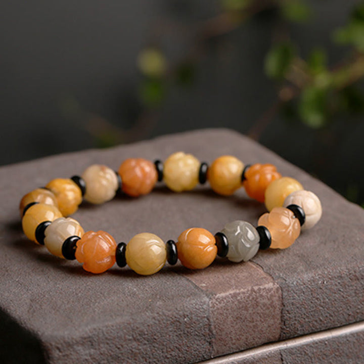 Jade Lotus Armband mit orangenen und cremefarbenen Perlen, schwarze Akzente, Glück Wohlstand.