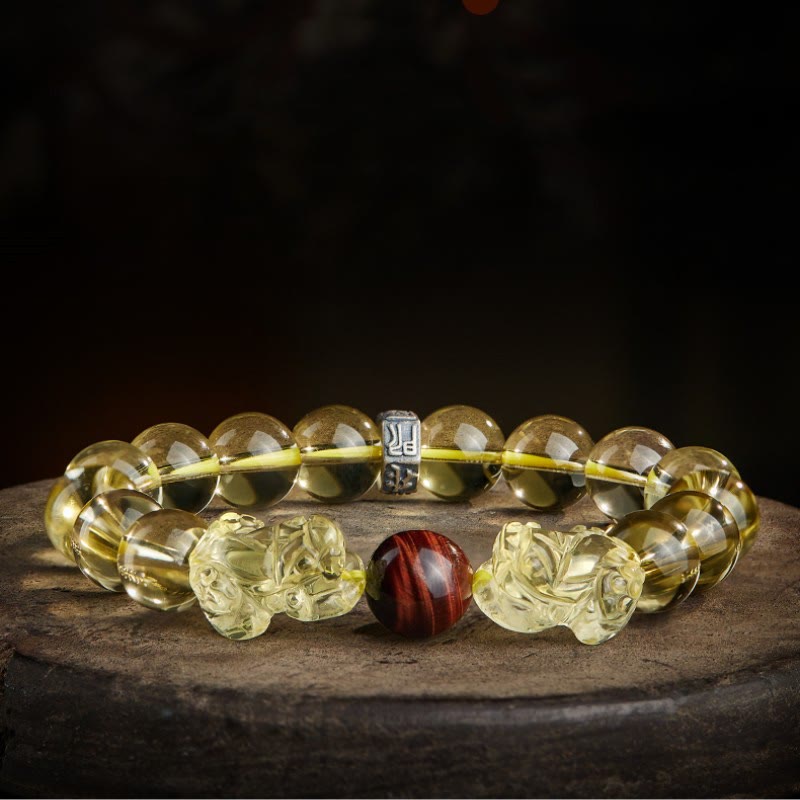 Armband mit Tigerauge, Citrin und Pixiu Schutzstein auf Stein.