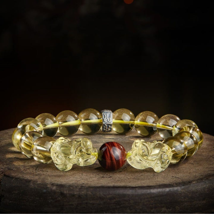 Armband mit Tigerauge, Citrin und Pixiu Schutzstein auf Stein.