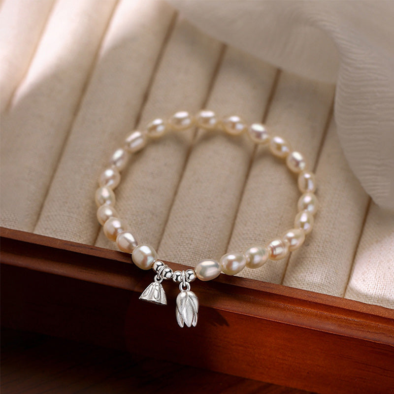 Perlarmband mit Silber Lotus Anhängern elegant am Handgelenk getragen