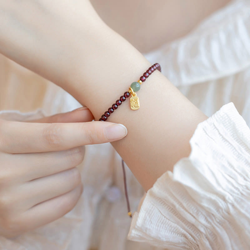 Armband Erdbeerquarz Granat Fu-Zeichen am Handgelenk getragen elegant