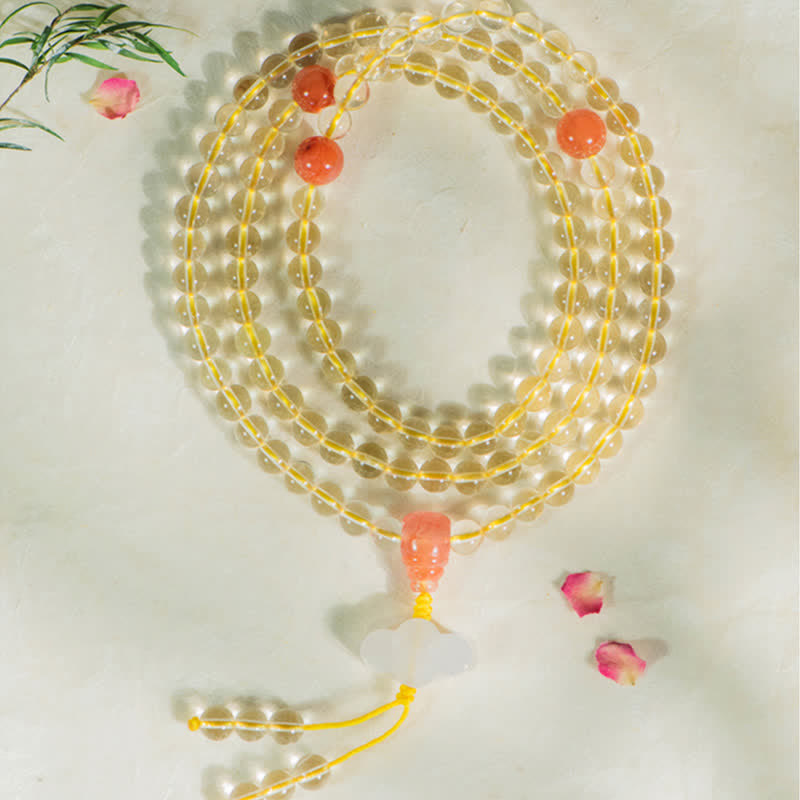 Citrin Mala Armband mit roten Korallenkugeln auf weißem Hintergrund.