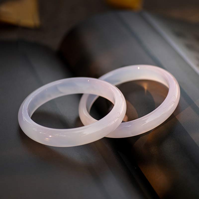 Armband – Harmonie zwei weiße Jade Ringe auf grauem Hintergrund elegant