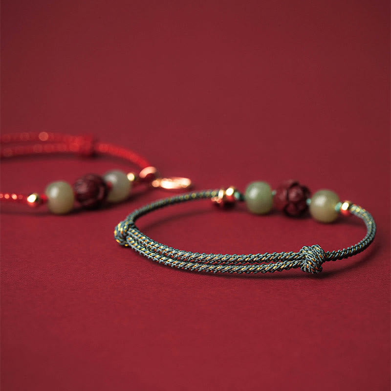 Armband Zinnober Jade Lotus – Glück mit Perlen auf rotem Hintergrund