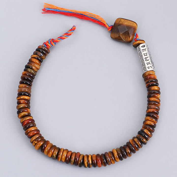 Tigerauge Armband Om Mani Padme Hum mit bunten Quasten auf neutralem Hintergrund.
