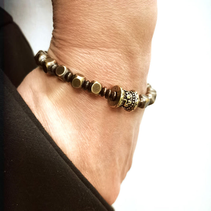 Kupfer Om Mani Padme Hum Armband mit goldenen Perlen am Handgelenk.