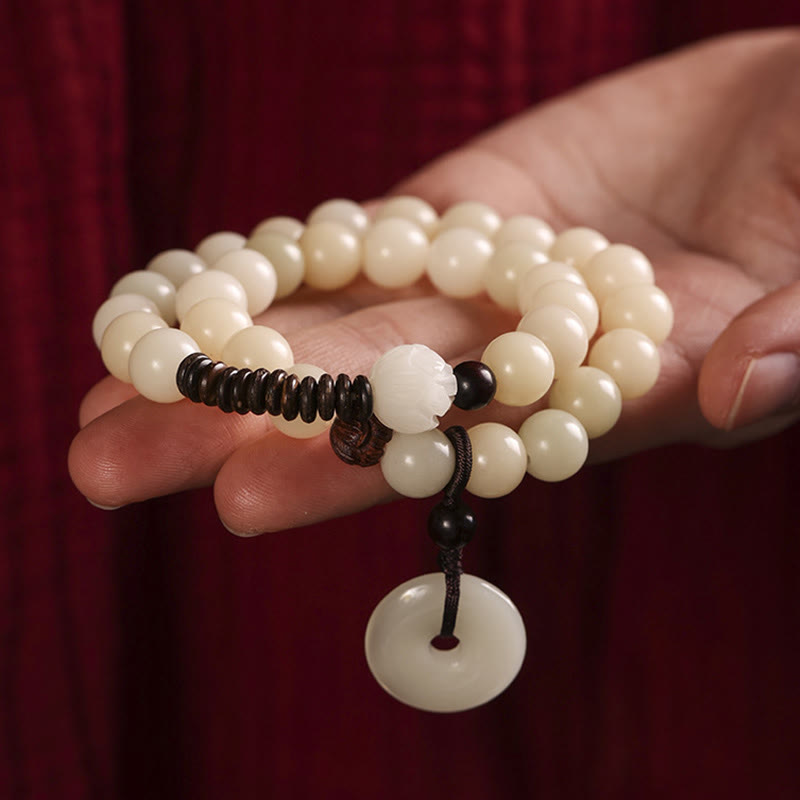 Sandelholz Bodhi Lotus Armband Handgelenk cremeweiße Perlen schwarze Kordel getragen