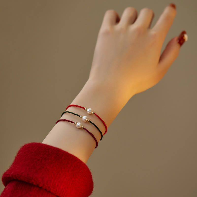 Armband Naturperle Geflochten am Handgelenk getragen rote schwarze Schnur Perlen
