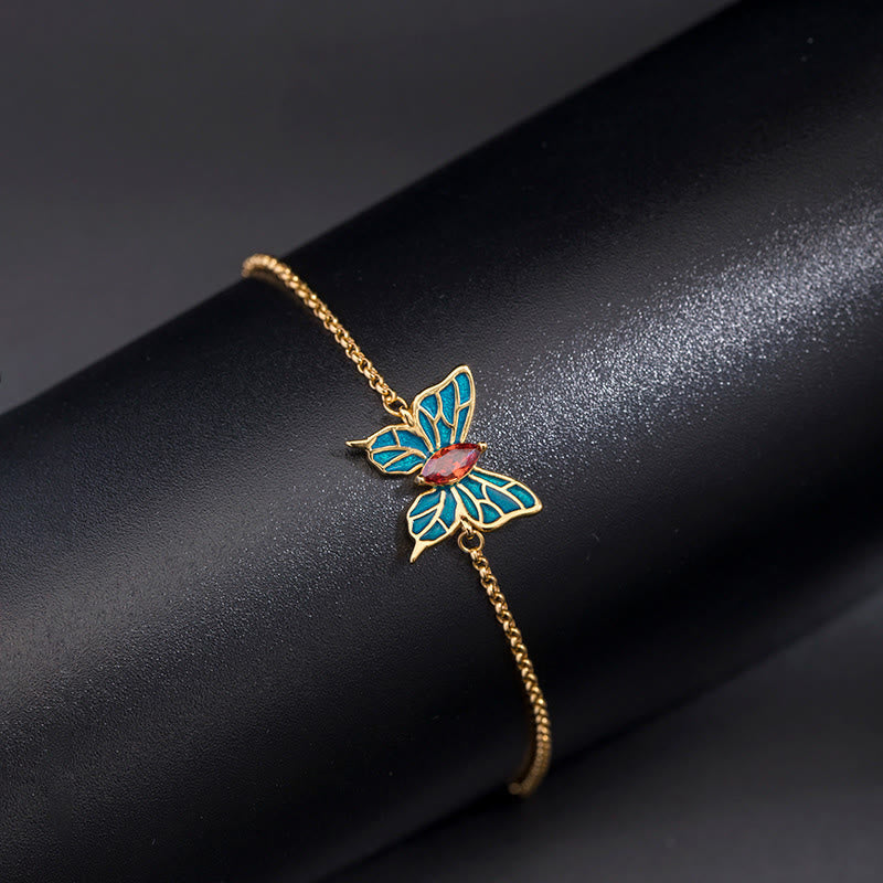 Goldenes Schmetterling Armband mit türkisen Flügeln elegant getragen.