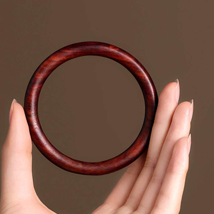 Dunkelrotes Sandelholz Armband in Hand gehalten Schutz Naturstein elegant