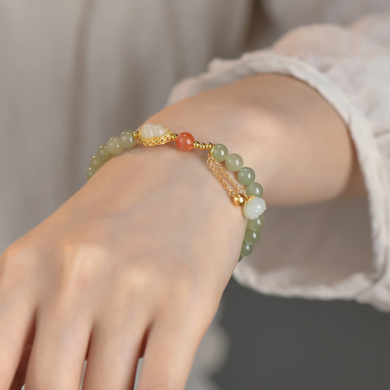 Jade Armband mit Lotus und roten Akzenten am Handgelenk getragen.