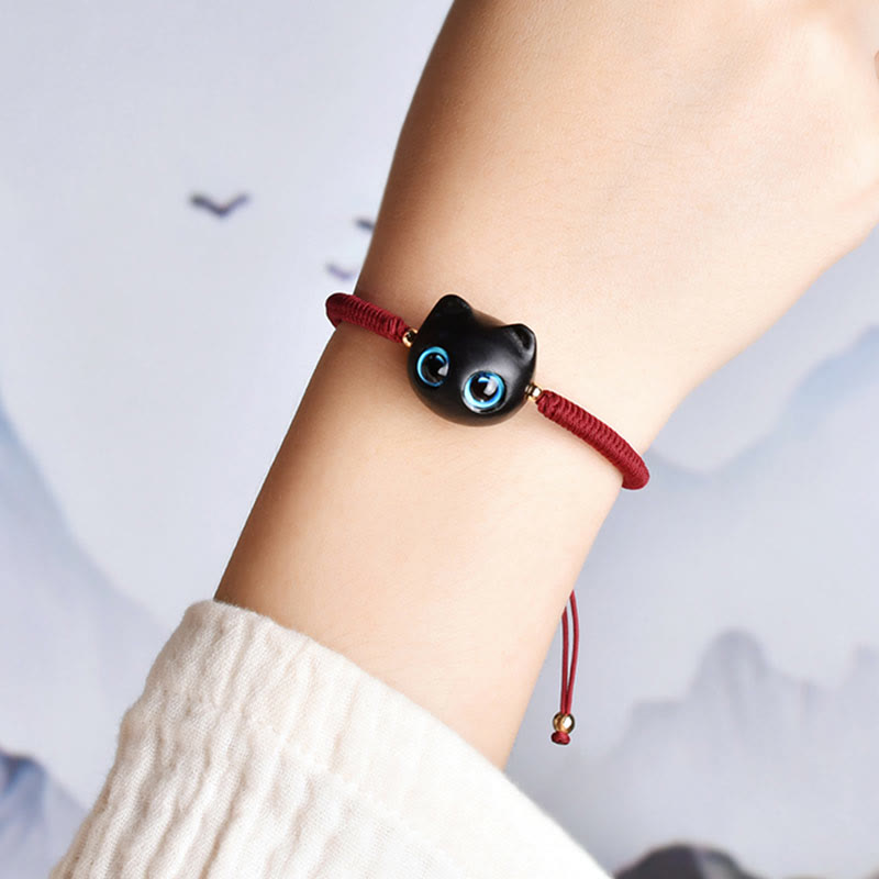 Armband Ebenholz Katze mit blauen Augen elastisch rot getragen