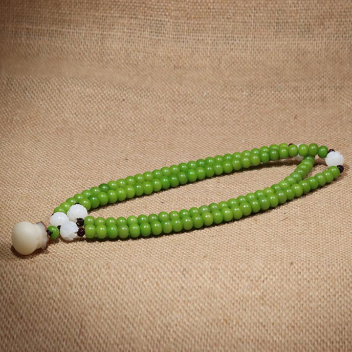 Grünes Mala Bodhi – Weisheit Armband mit weißen Perlen elastisch.