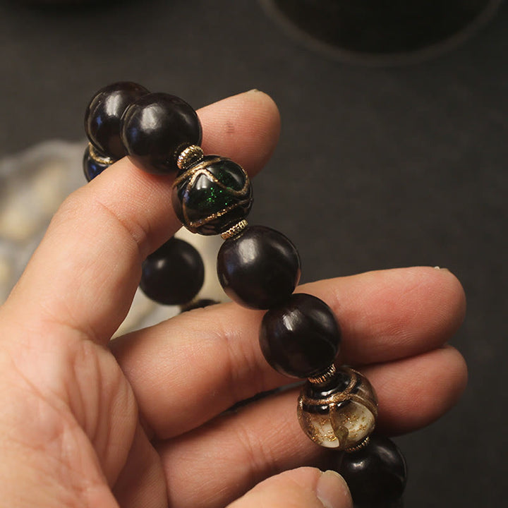 Armband – Wohlstand Harmonie schwarze Perlen Naturstein elastisch getragen
