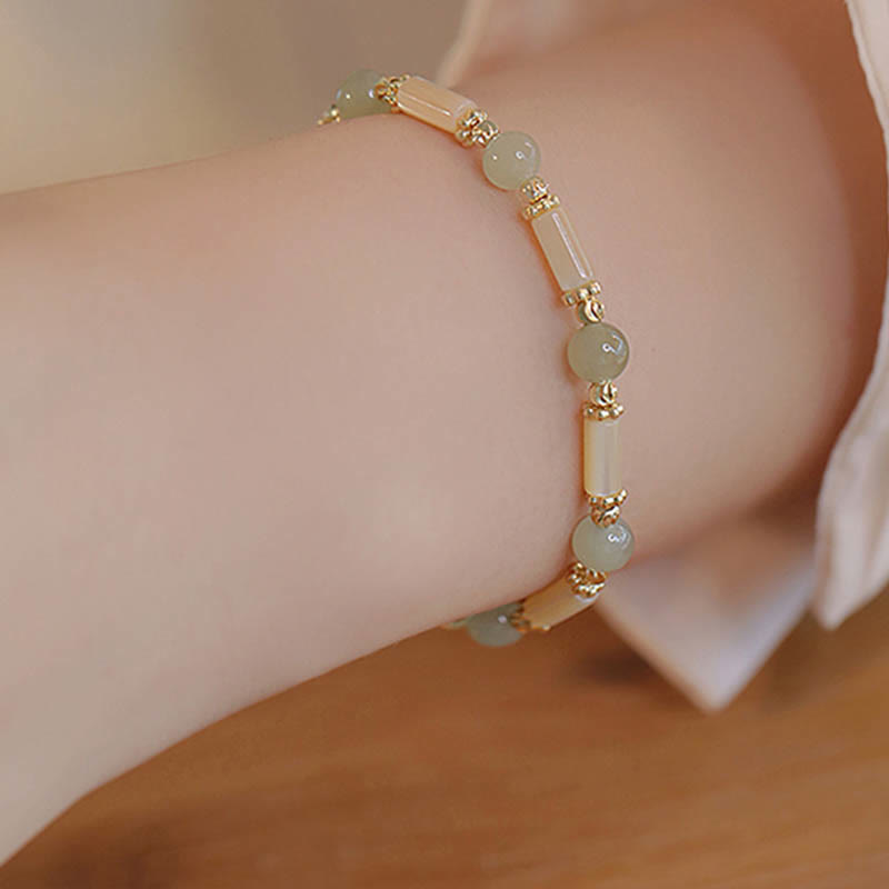 Jade Armband mit goldfarbenen Perlen am Handgelenk getragen elegant