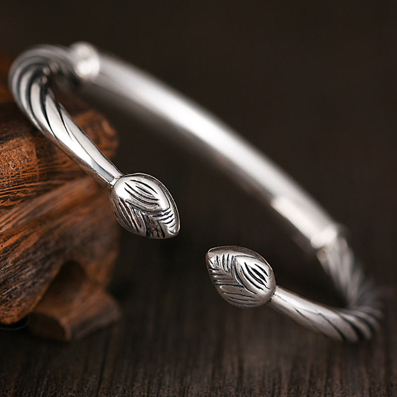 Silbernes Armband mit Blattmotiven auf Holz Nahaufnahme Schmuck.
