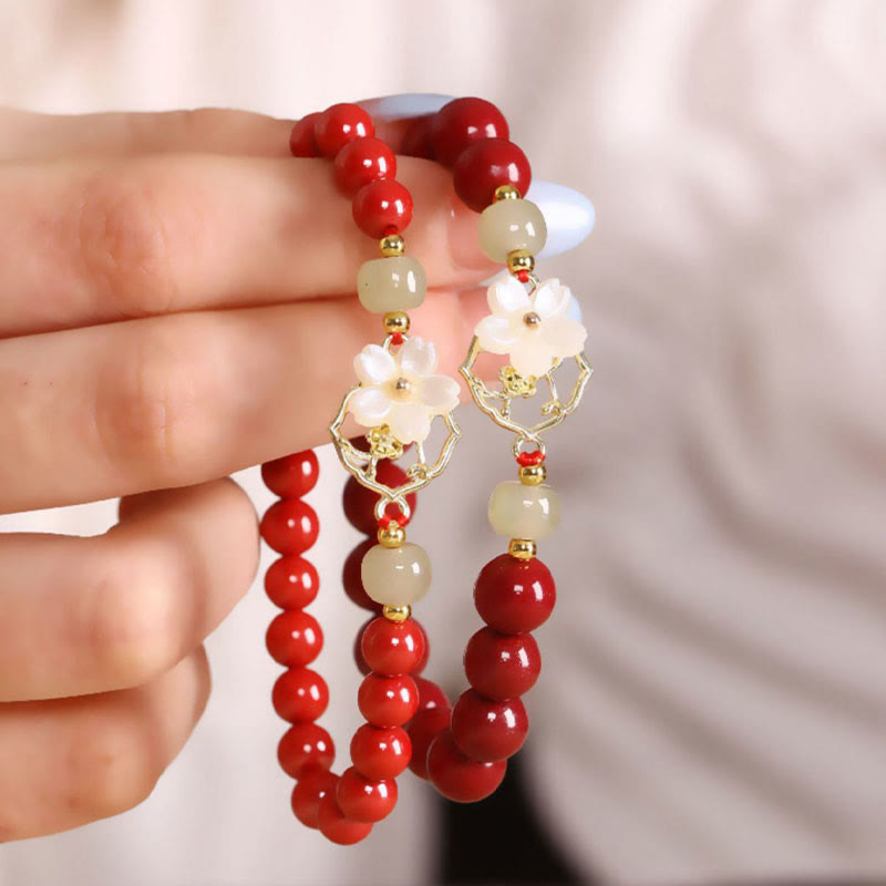 Armband Zinnober Jade – Segen mit roten Perlen am Handgelenk getragen.