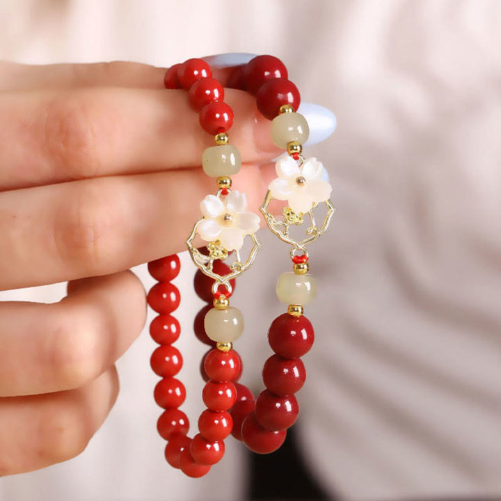 Armband Zinnober Jade – Segen mit roten Perlen am Handgelenk getragen.
