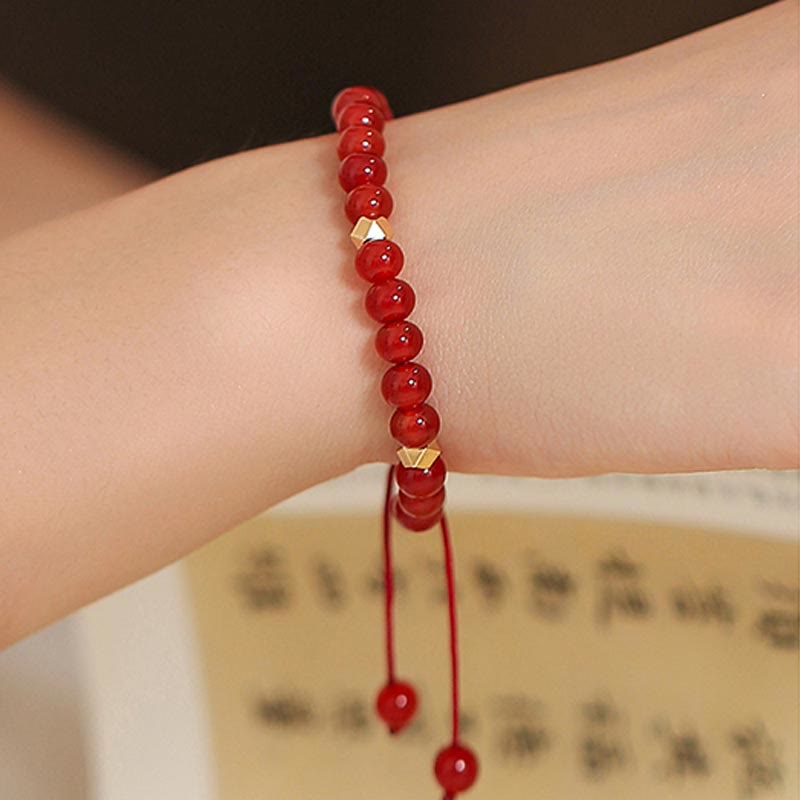 Rotes Achat Armband mit goldenen Perlen am Handgelenk getragen elegant